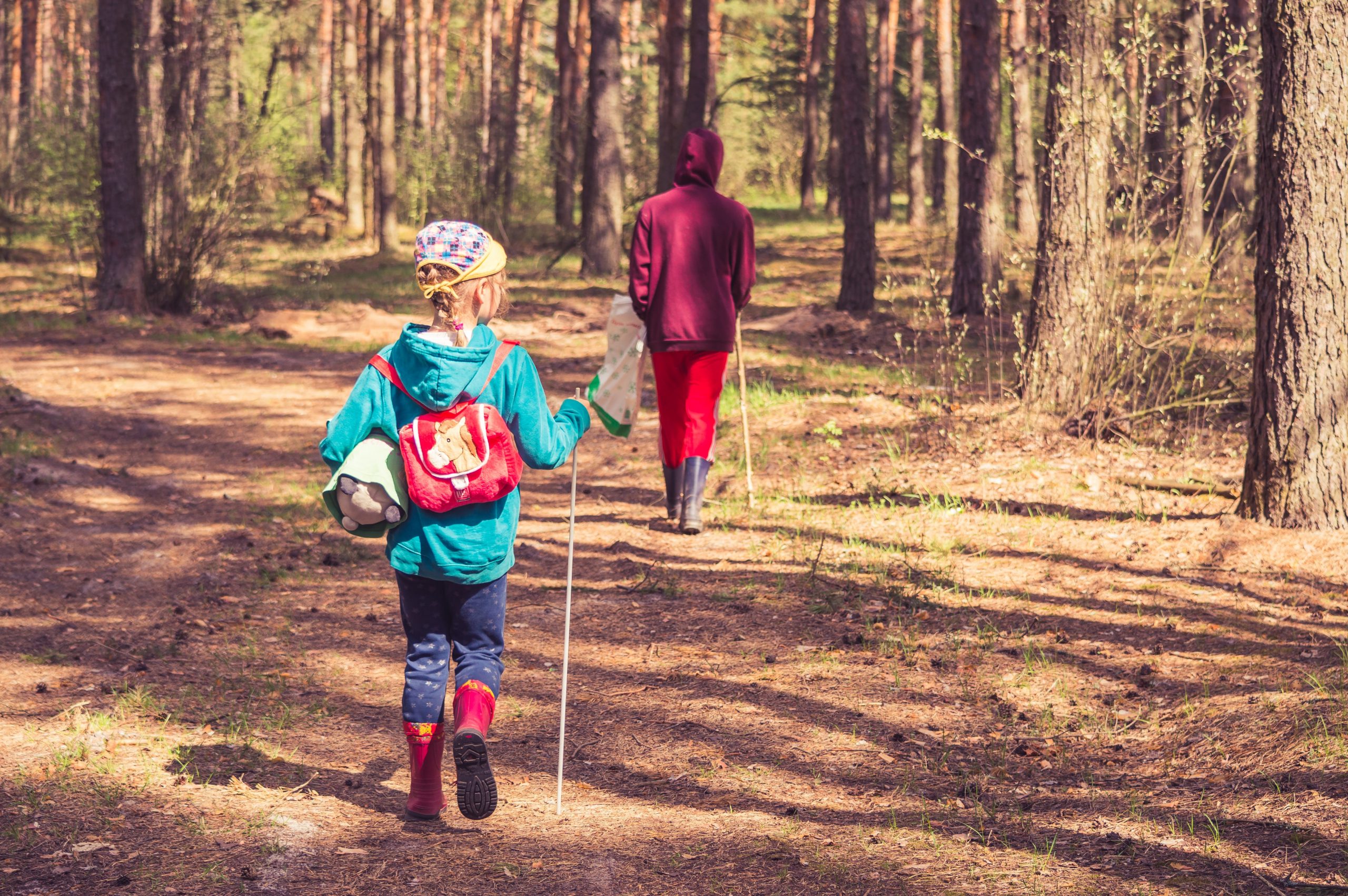 A daughter and her mother hike a wooded trail together
