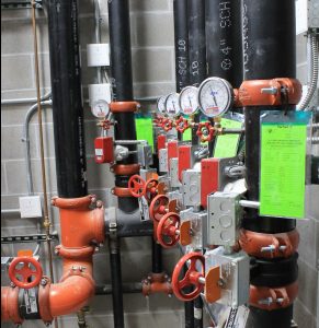 Image of facility plumbing and fire sprinkler system components inside the Wisconsin Dells High School.