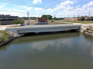 Side-angle photograph of a new bridge with decorative stone finishes in the City of Kaukauna, Wisconsin. 