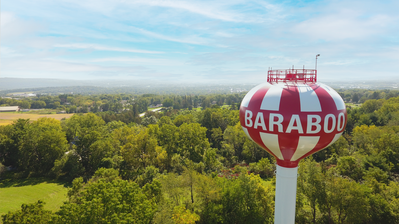 Aerial photograph of red and white striped water tower in Baraboo, Wisconsin, that resembles a circus tent and pays homage to the cultural roots of the community as home to the Ringling Brothers and Circus World Museum.